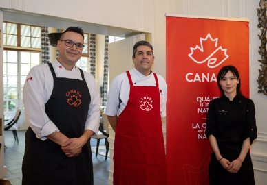 People posing next to a Canada Brand banner