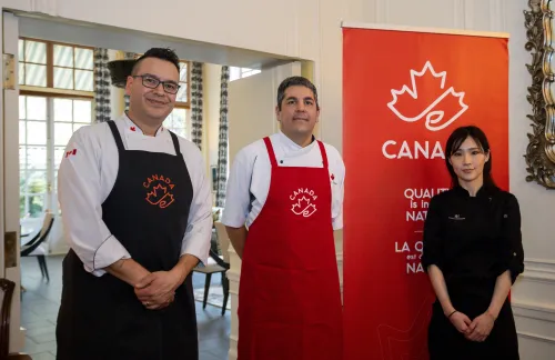 People posing next to a Canada Brand banner